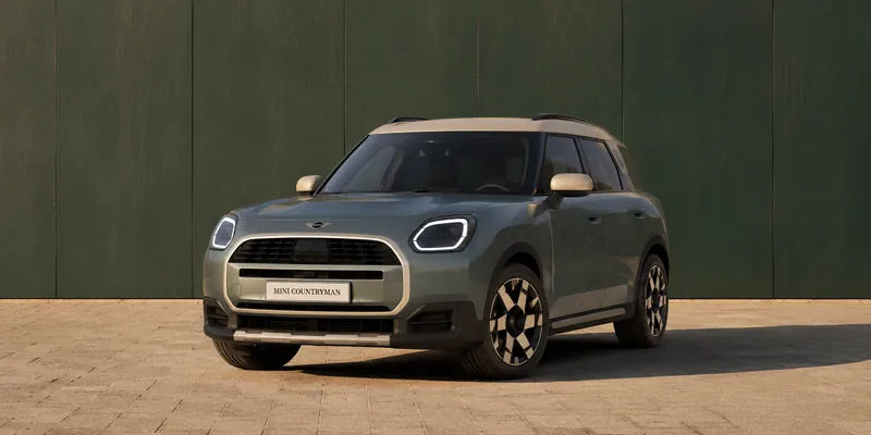 Le MINI Countryman Smokey Green devant un mur vert profond.